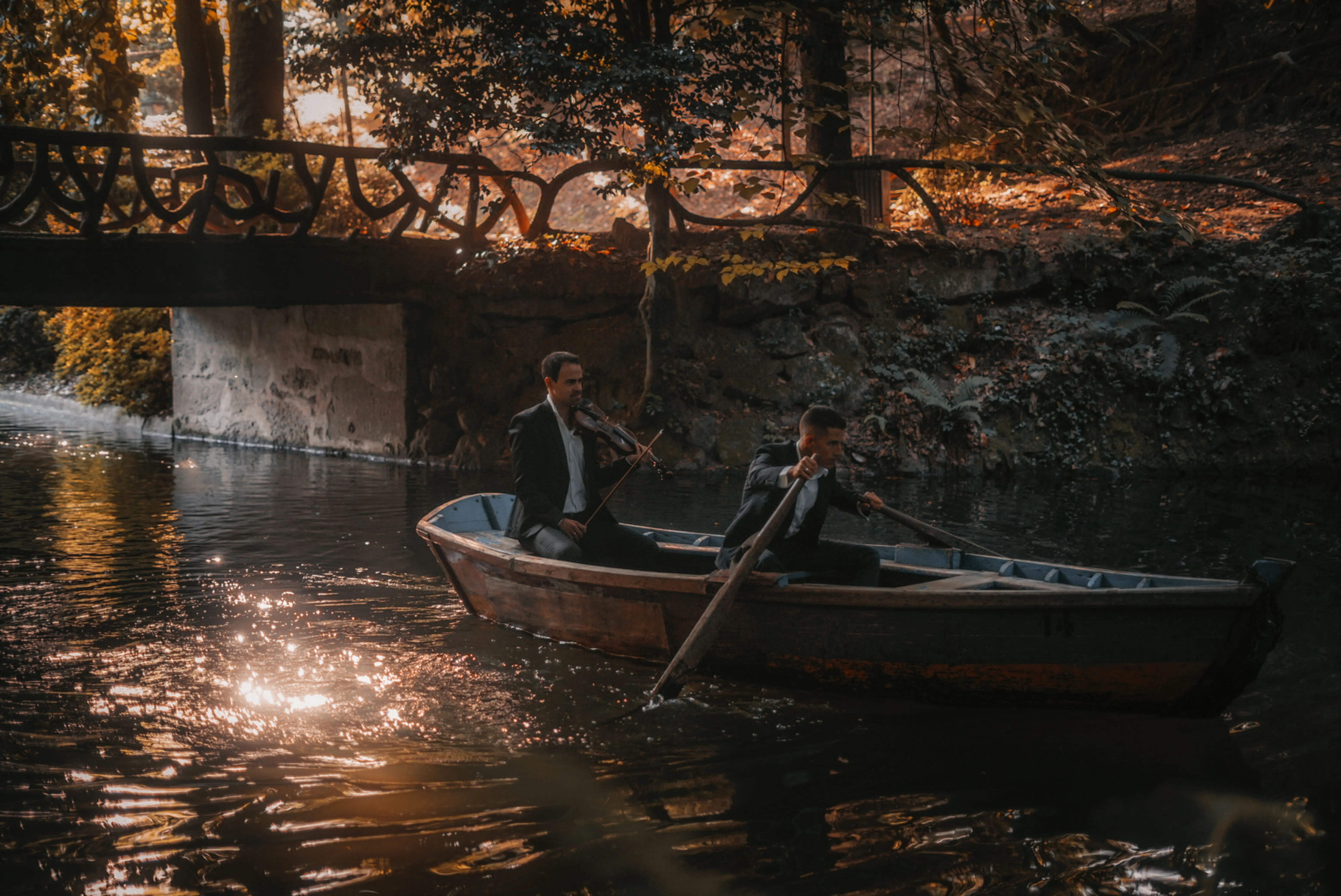 Rafael Xavier rowing a canoe while E. Sousa plays violin on Bom Jesus lake in Braga, Portugal, during the production of the music video Só Hoje Vi
