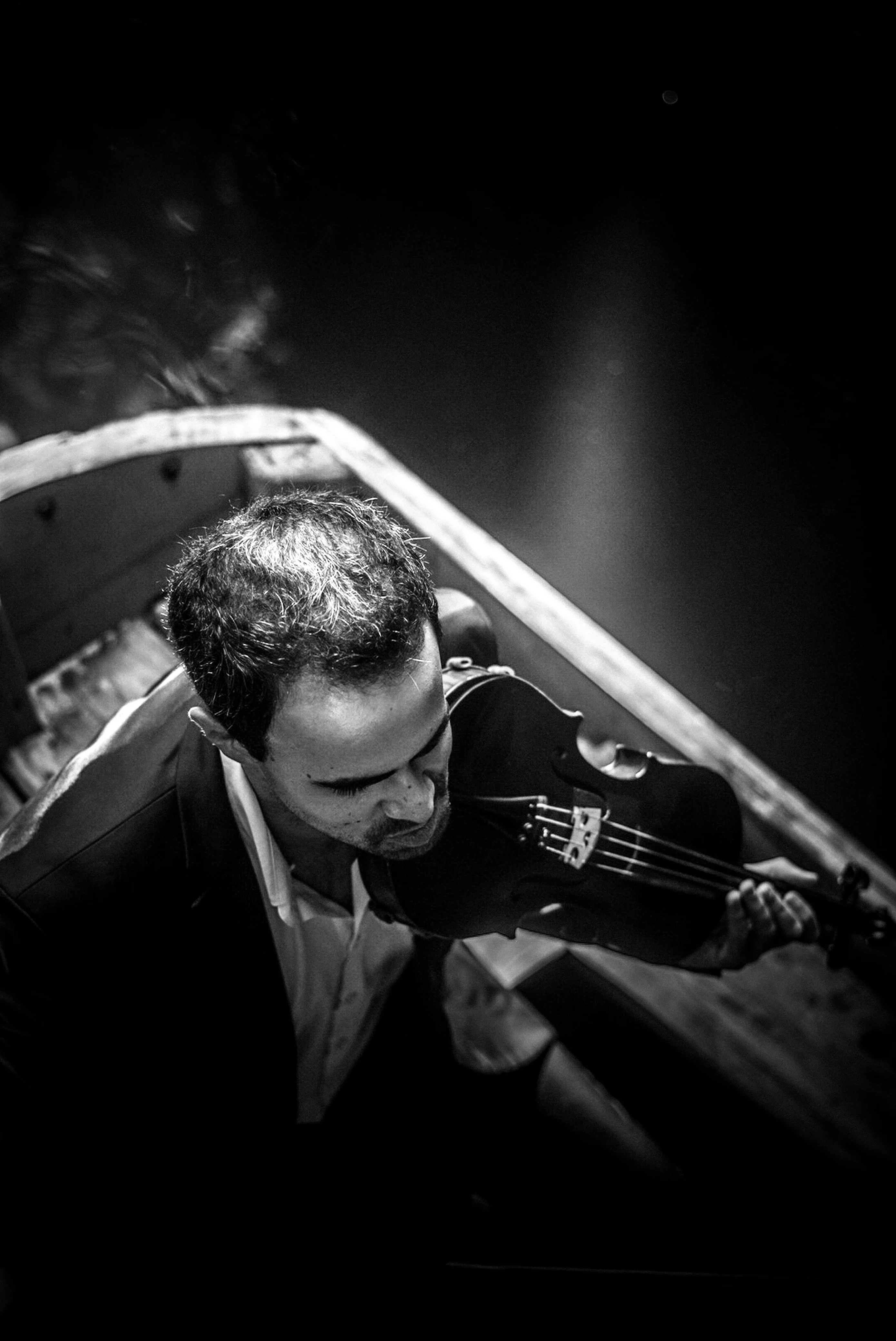 E. Sousa playing violin in a canoe during the production of Rafael Xavier's music video Só Hoje Vi